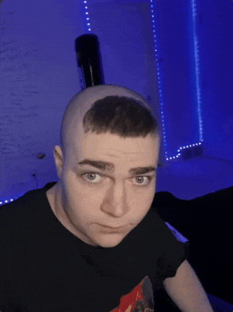 a man with a shaved head is wearing a black shirt with a picture on it