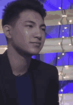 a close up of a man 's face in front of a blue wall