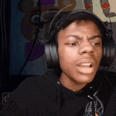 a young man wearing headphones is making a funny face .