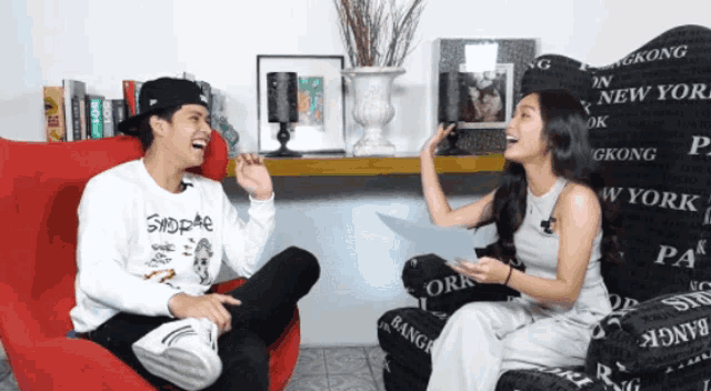a man and a woman are sitting in a chair that says gkong on it