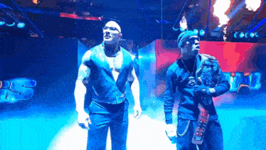 a couple of men are standing next to each other on a stage in a dark room .