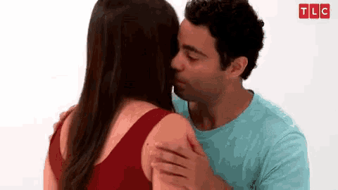 a man and a woman are kissing each other .