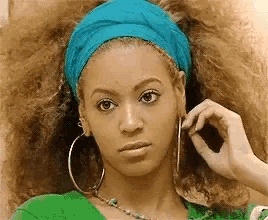 a woman with a blue headband and hoop earrings