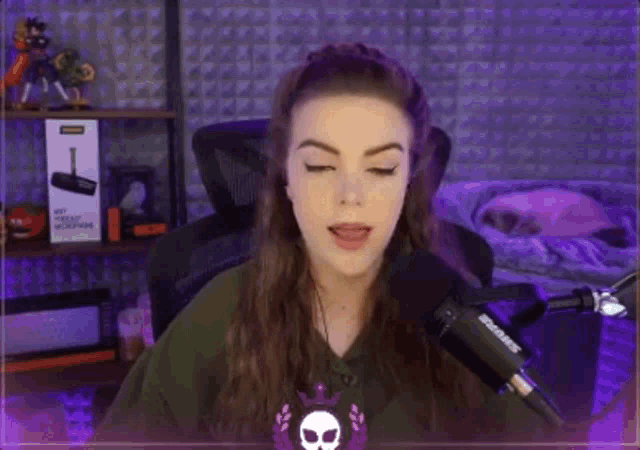 a woman is sitting in front of a microphone in a purple room .