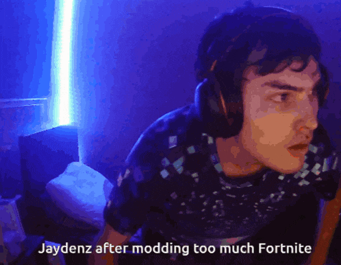 a man wearing headphones says jaydenz after modding too much fortnite in a dark room