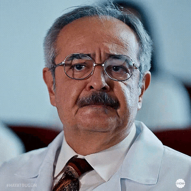 a man with glasses and a mustache is wearing a white coat