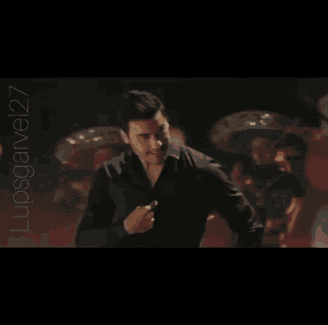 a man in a black shirt is dancing in front of mariachi players and the hashtag lupsgarvel27