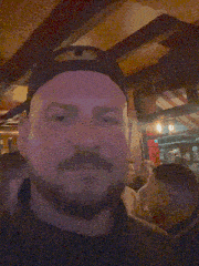 a blurry picture of a group of people including a man wearing a baseball cap