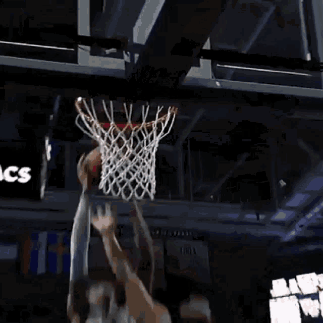 a basketball player is dribbling a basketball in a crowd of people .