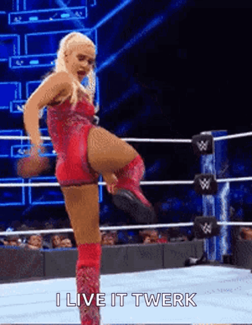 a woman in a red leotard is kicking her leg in a wrestling ring .