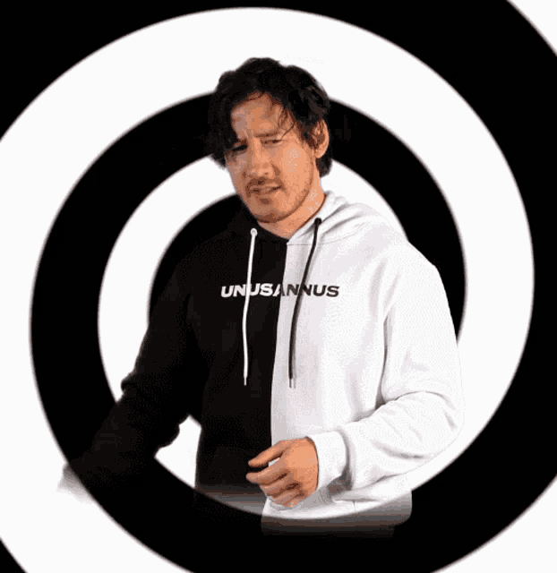 a man wearing a black and white hoodie that says unusannus on it
