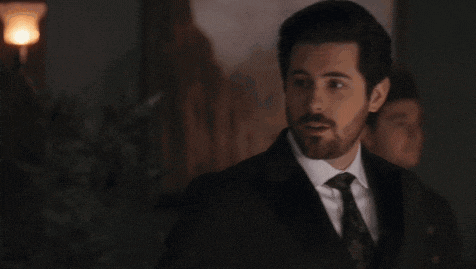 a man with a beard is wearing a suit and tie .