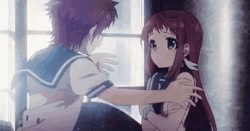 a boy and a girl are hugging each other in front of a window in a room .