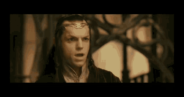 a man with a crown on his head is looking at the camera