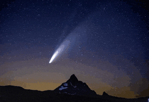 a comet is flying through a starry night sky over a mountain