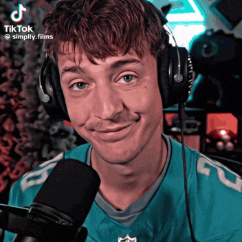 a man wearing headphones is smiling in front of a microphone with tiktok simply.films written on the bottom