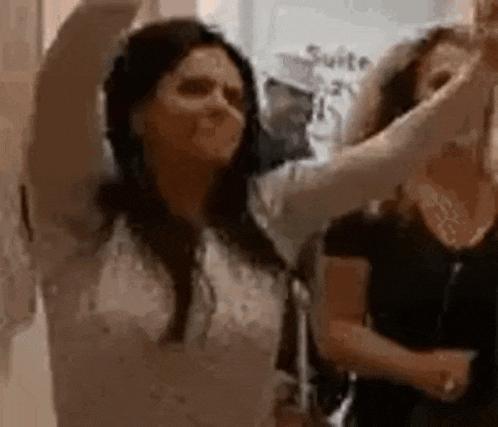 a woman is dancing with her arms in the air .