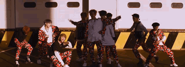 a group of young men in camouflage pants are standing in a line