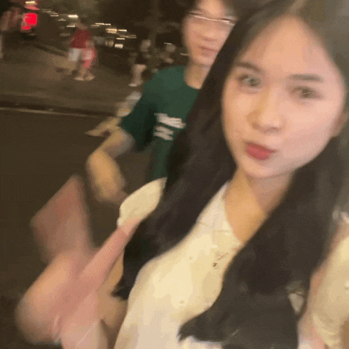 a man in a green shirt with the letter h on it stands next to a woman