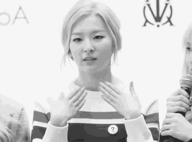 a woman wearing a striped sweater has a question mark on her sweater