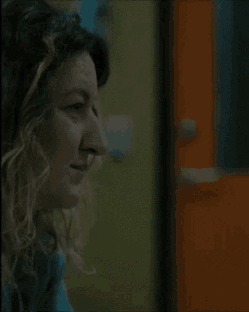 a close up of a woman 's face with a door in the background .