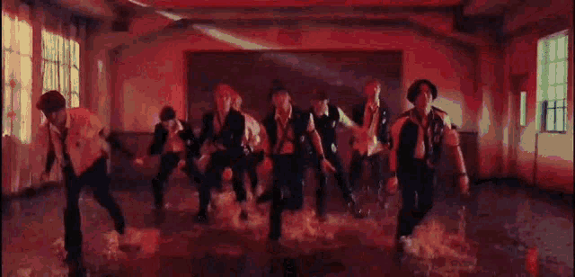 a group of people are dancing in a room with water .