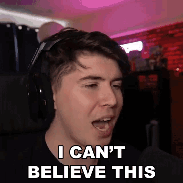 a man wearing headphones says " i can 't believe this " in front of a microphone