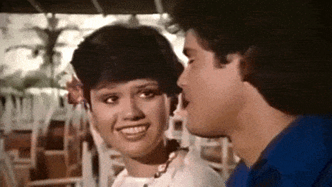 a man is kissing a woman on the cheek and the woman is smiling