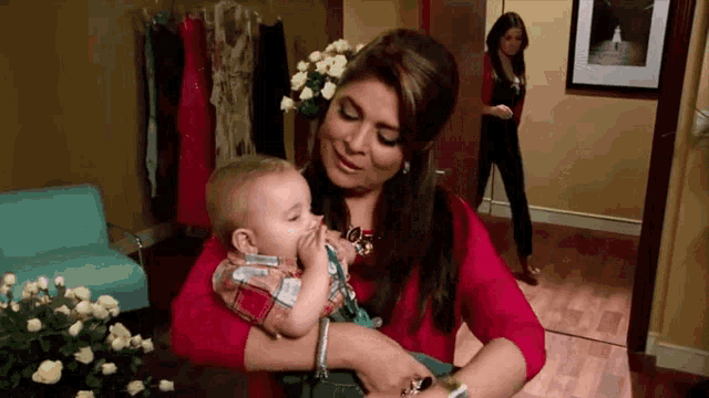 a woman is holding a baby in her arms