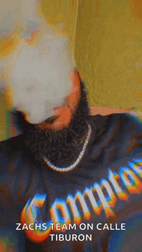 a man with a beard wears a compton shirt