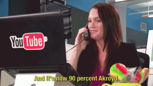 a woman is talking on a cell phone in front of a youtube laptop