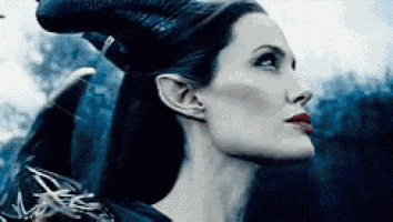 a woman with horns on her head is wearing a blue dress and red lipstick .