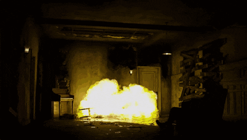 a man sits in a chair in front of a room that is on fire