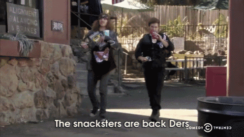 two people are walking down a street with the words " the snacksters are back ders " in the corner