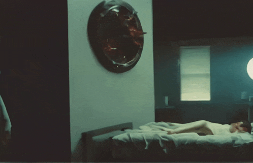 a woman is laying on a bed in a dark room