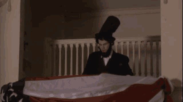 a man with a beard and top hat holds an american flag
