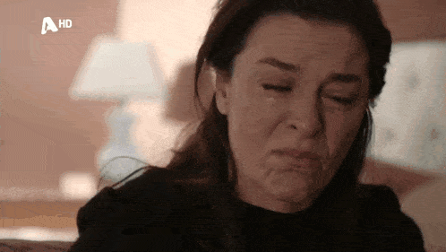 a woman is crying with her eyes closed and her mouth open .