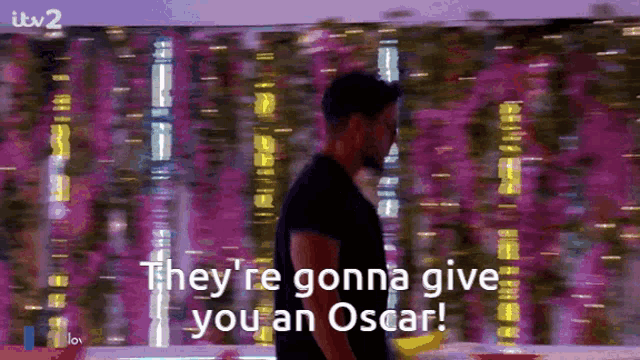 a man says they 're gonna give you an oscar in front of a purple background
