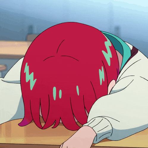 a girl with red hair is laying down with her head on a table