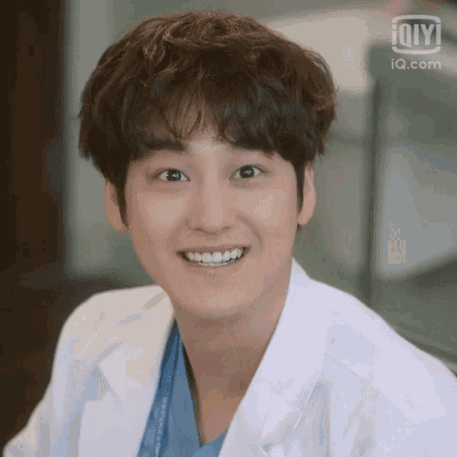 a close up of a person wearing a lab coat and smiling .