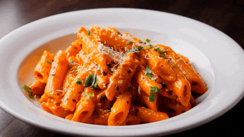 a white plate topped with pasta with sauce and cheese