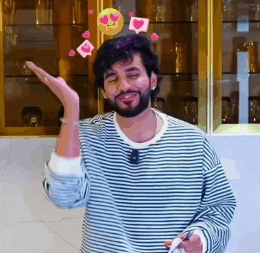 a man with a beard is wearing a striped shirt with hearts coming out of it