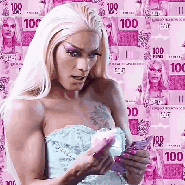a woman standing in front of a wall of pink 100 reais bills
