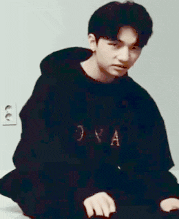 a young man is wearing a black hoodie with the letter a on it .