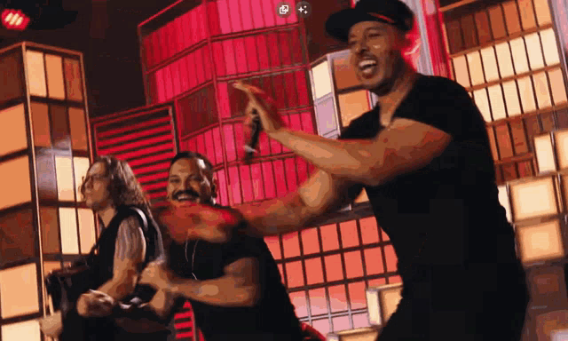 a group of men are dancing in front of a building