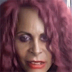 a close up of a woman 's face with pink hair .