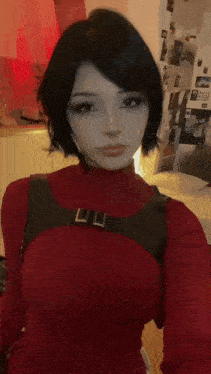 a woman wearing a red sweater and a black harness is taking a selfie in a bedroom .