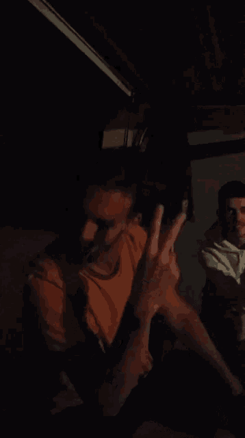 a blurry picture of a man covering his mouth with his hand in the dark .