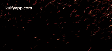 a large explosion of fire with sparks coming out of it on a black background