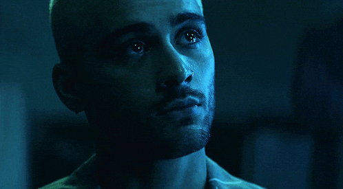 a man with a nose ring and earrings looks at the camera